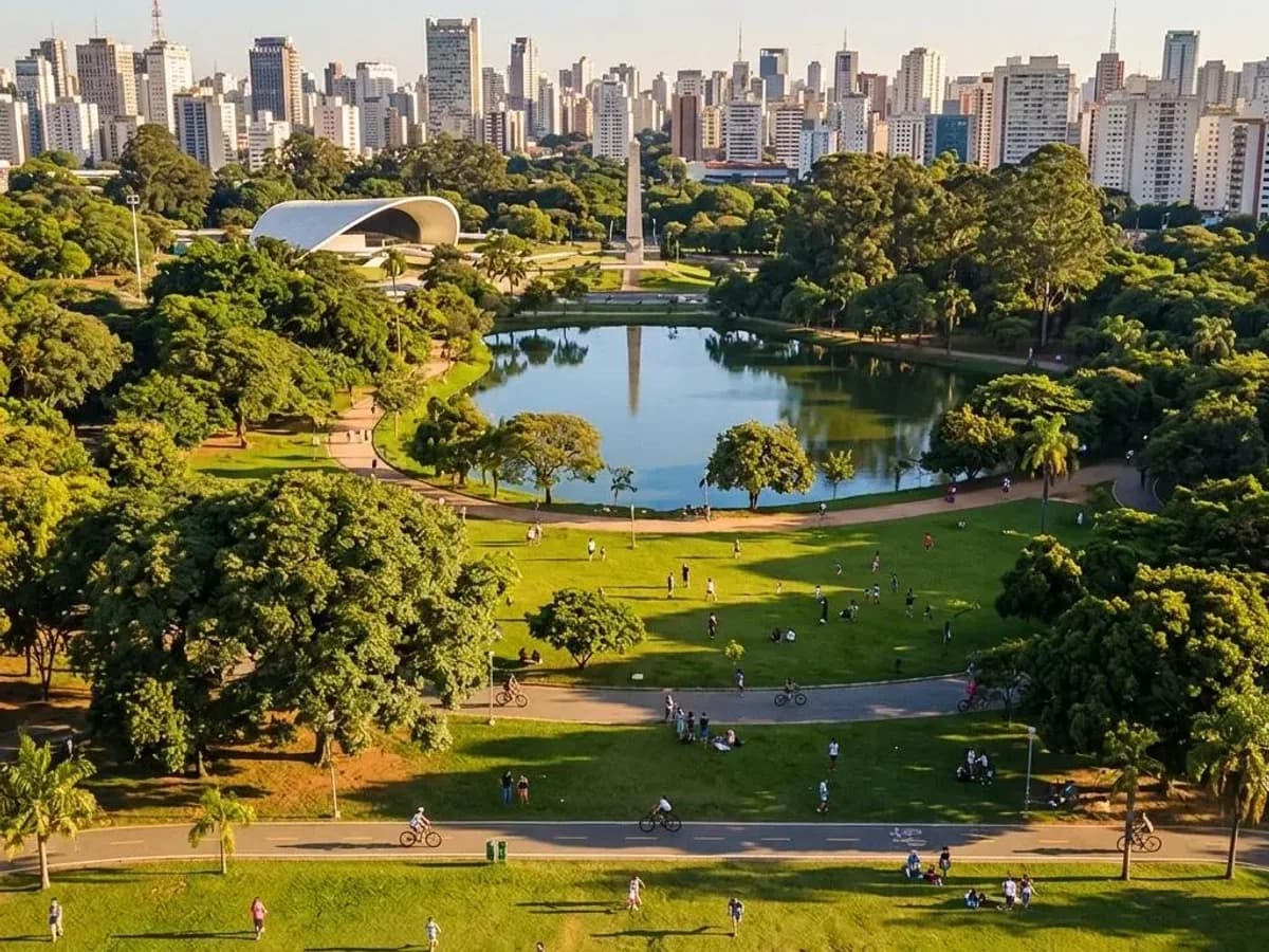 Vista aérea do Parque Ibirapuera em São Paulo, com o lago, a Oca e o skyline da cidade ao fundo