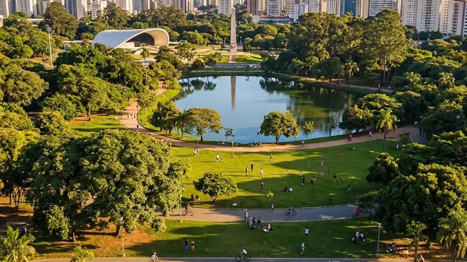 Vista aérea do Parque Ibirapuera em São Paulo, com o lago, a Oca e o skyline da cidade ao fundo